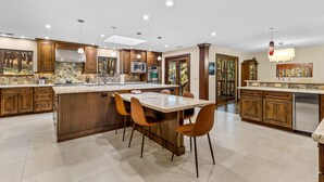 A spacious kitchen with wooden cabinets, a large island, and modern lighting. - Slippery Rock Vacation Home - sleeps 9 (Flagstaff)