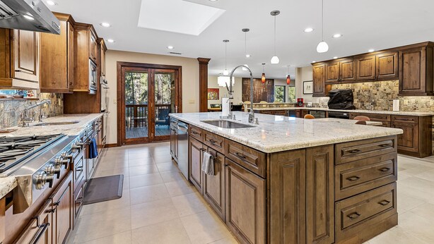A spacious kitchen with wooden cabinets, a large island, and a skylight. - Slippery Rock Vacation Home - sleeps 9 (Flagstaff)