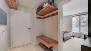 Een slaapkamer met een stapelbed, een bureau, een raam met uitzicht en een deur.