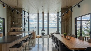 Et moderne køkken med bar, store vinduer og havudsigt.