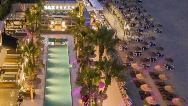 A resort with a pool, palm trees, and beach umbrellas. - Spectacular Penthouse with panoramic sea views in Riviera del Sol (Mijas-Costa)