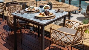 An outdoor dining area with tables and chairs, a palm tree, and a view of the ocean. - Spectacular Penthouse with panoramic sea views in Riviera del Sol (Mijas-Costa)