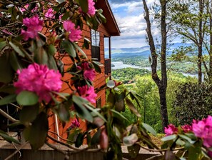 A wooden cabin with a view of a lake and mountains.