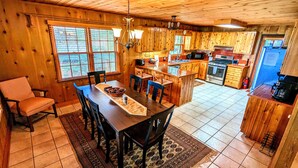 L’intérieur d’une cabane en bois comprend un coin repas, une cuisine et un petit îlot central.