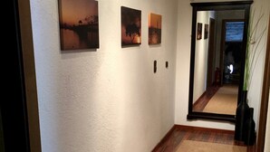 A hallway with a wooden floor, white walls, and three framed pictures. - Gemütliche Ferienwohnung im Dorfzentrum mit Garten für 2- 6 Personen (Aschau im Zillertal)