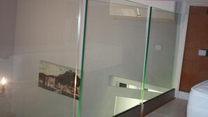 Ein Zimmer mit Glastrennwand, einer weißen Tür und einem kleinen Bild an der Wand.