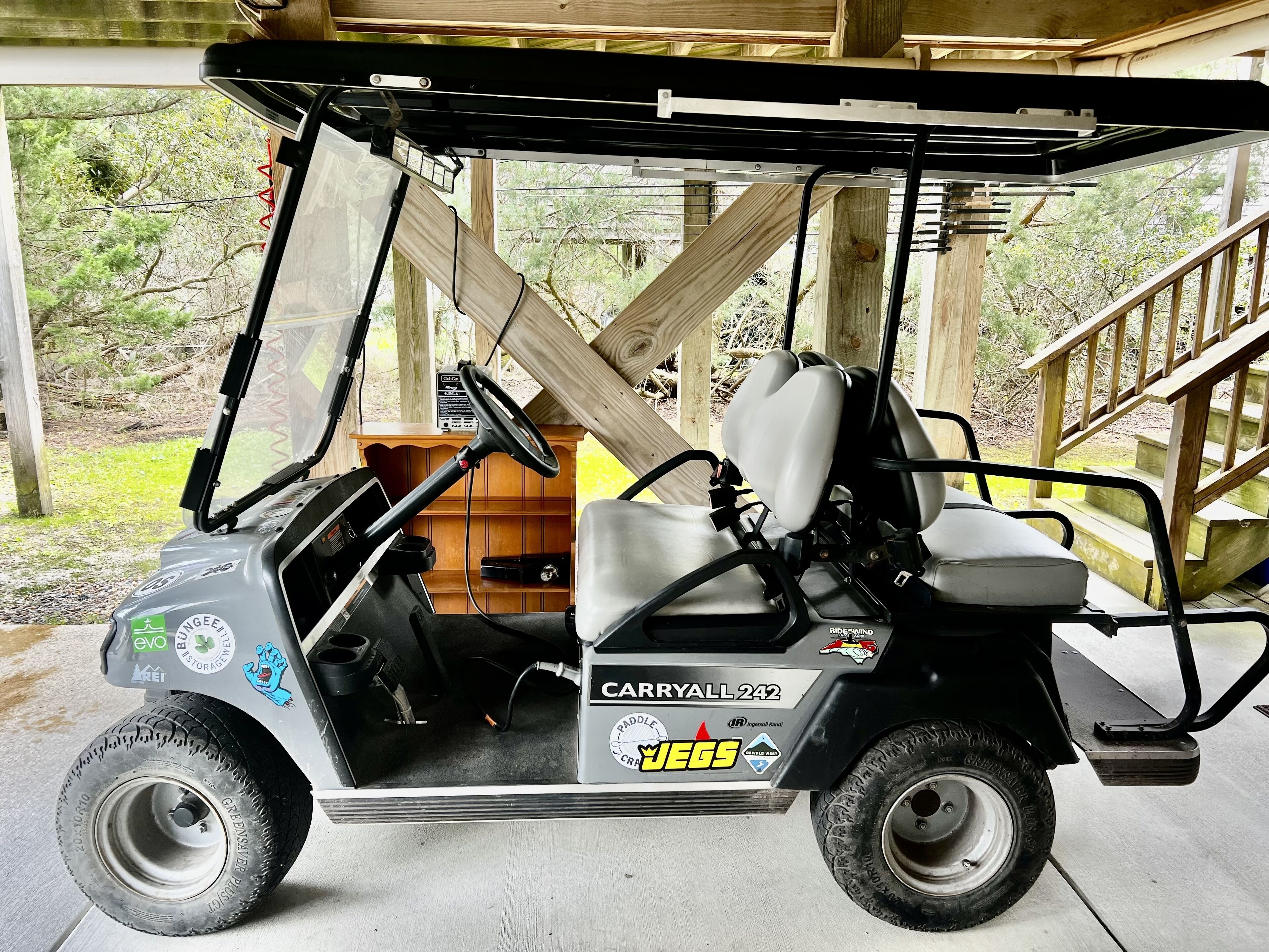 A golf cart with a wooden structure in the background.
