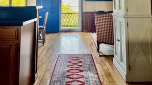 A spacious room with a wooden ceiling, a large window, and a view of the outdoors. - Three-bedroom house with views, decks, golf cart and home gym! (Ocracoke)