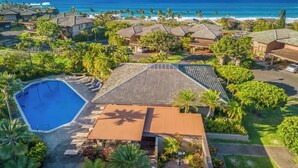 Un quartier résidentiel doté d’une piscine, de maisons aux toits inclinés et offrant une vue sur l’océan.