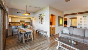 Un salon moderne avec un canapé, une table à manger et une cuisine en arrière-plan.
