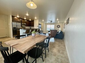 Enjoy meals in this spacious dining area with a wooden table and comfortable seating.