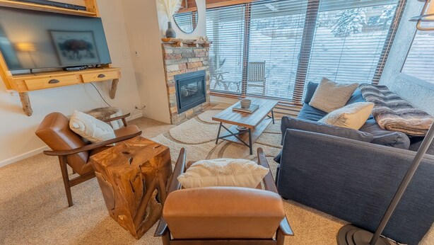 A cozy living room with a fireplace, a television, and comfortable seating.