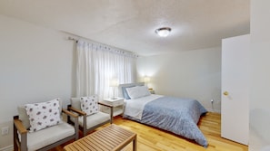 A small, clean room with a bed, two chairs, a nightstand, and a wooden table. - 3-Bed 3-Bath Cozy Vacation House in Ajax, Greater Toronto Area GTA, ON, Canada (Ajax)