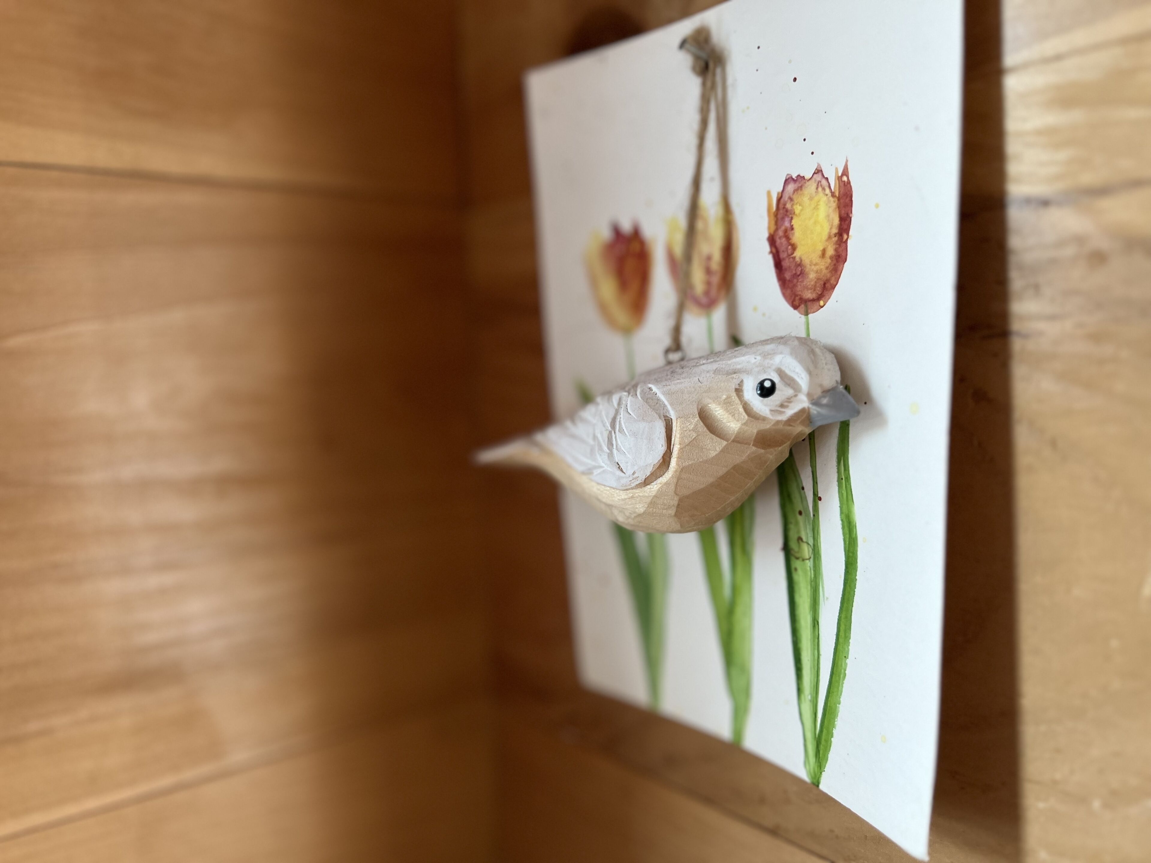 A wooden cabinet with a whiteboard displaying a drawing of a bird and tulips.