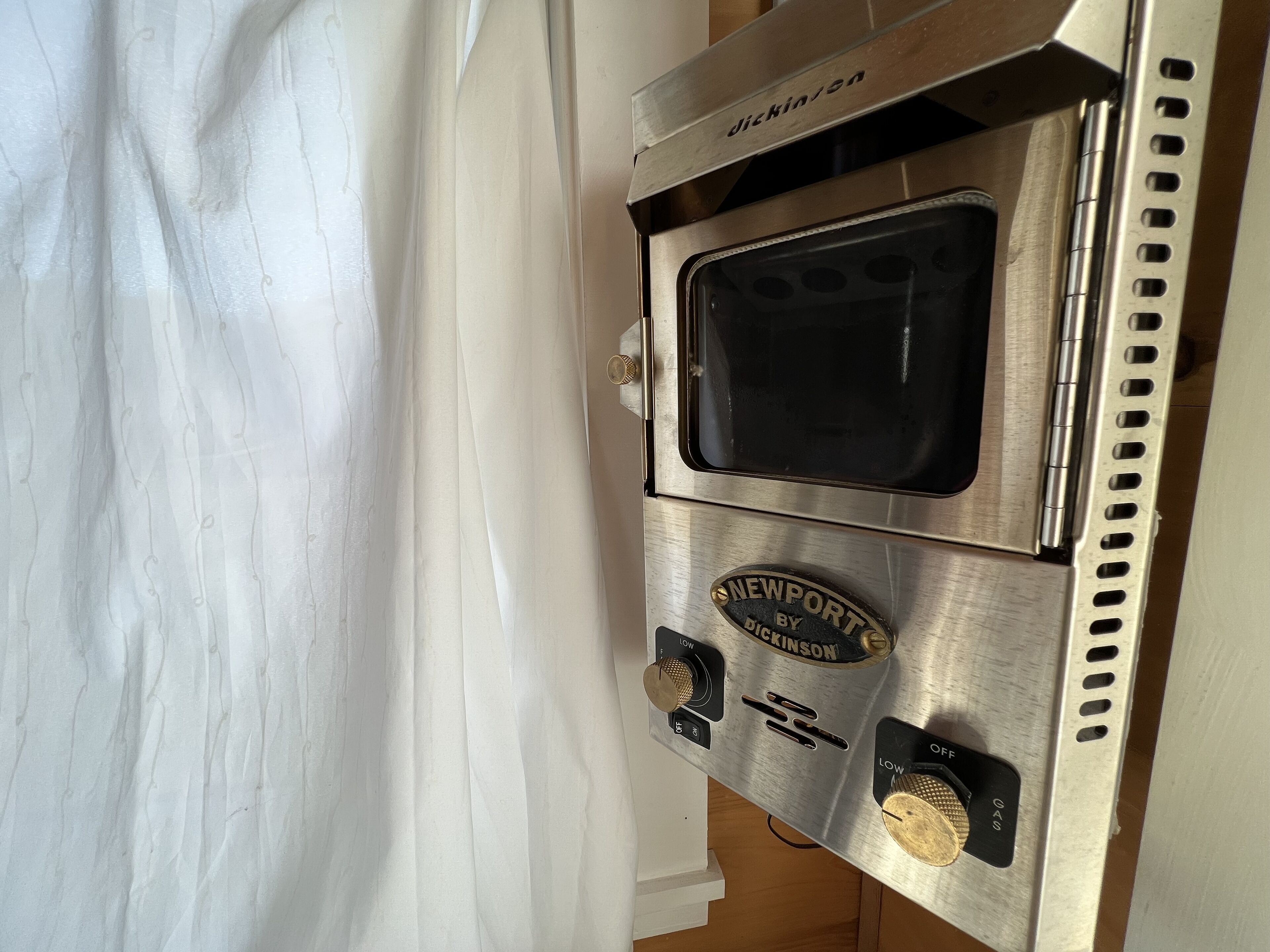 A stainless steel oven with a control panel, a window, and a brand name "Newport by Dickinson".