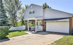 Two-story house with a covered patio and a well-manicured lawn.