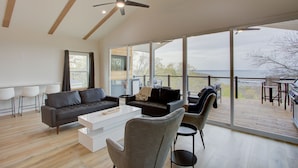 A spacious living area with a modern design, featuring a large sofa, a coffee table, and a seating area with chairs. - Breathtaking Views of Lake Texoma's beaches/Islands and Highport Marina.
 (Pottsboro)