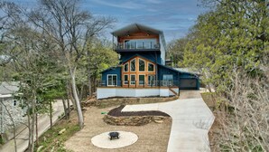 A modern two-story house with a balcony, a stone retaining wall, and a concrete pathway. - Breathtaking Views of Lake Texoma's beaches/Islands and Highport Marina.
 (Pottsboro)