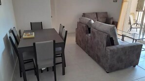 Una sala de estar moderna con una mesa de comedor y un juego de sofá.