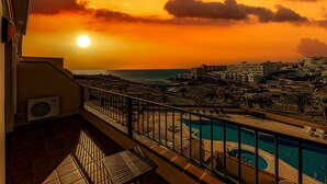 A balcony with a pool and a view of the ocean at sunset. - HOUSE OF THE SEA (Callao Salvaje)