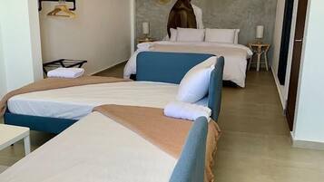 A hotel room with two beds, a hanging light fixture, and a large abstract painting on the wall.