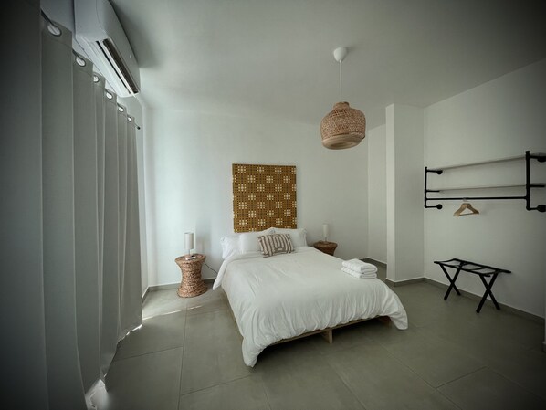 Un dormitorio moderno con cama, mesitas de noche, lámpara colgante y estante de pared.