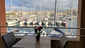 A view from a balcony overlooking a marina with multiple boats docked.