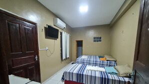 A small, well-lit room with two beds, a TV, and a refrigerator. - Pousada Meireles Praia (Fortaleza)