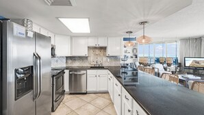 Una cocina moderna con armarios blancos, electrodomésticos de acero inoxidable y una isla grande.