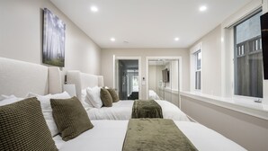 Habitación de hotel con una cama grande, un espejo, una ventana y un cuadro en la pared.