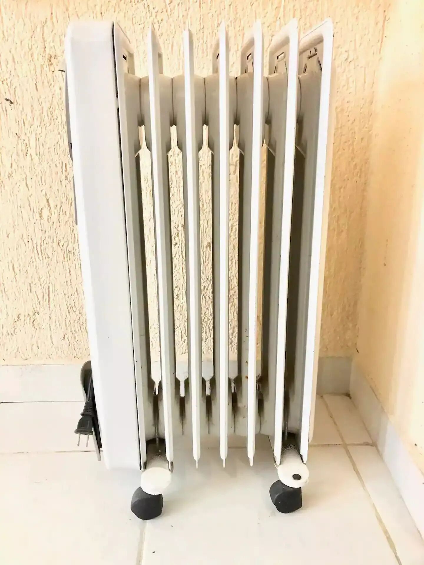 Un radiateur doté de plusieurs ouvertures, placé contre un mur à texture.