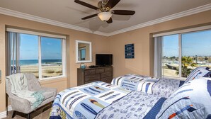 A bedroom with a large bed, a chair, a dresser, a television, and a view of the beach. - North Coast Village 3brm Penthouse - Amazing Oceanfront Panoramic Views -  G315 (Oceanside)
