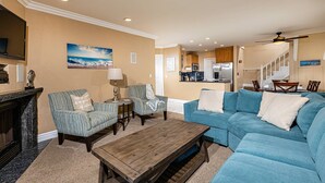 A living room with a fireplace, striped armchairs, a blue sofa, and a wooden coffee table. - North Coast Village 3brm Penthouse - Amazing Oceanfront Panoramic Views -  G315 (Oceanside)