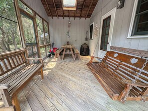 A wooden deck with benches, a picnic table, and a hanging wind chime. - Atlantic Shanty - Quaint 3 BR Oceanside home in Southern Shores (Southern Shores)