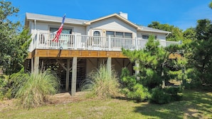A two-story house with a wooden deck and an American flag. - Hameljuice - Classic 3 BR Oceanside Beach Cottage - close to beach (Southern Shores)