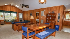 A wooden interior with a dining area, seating, and a ceiling fan. - Hameljuice - Classic 3 BR Oceanside Beach Cottage - close to beach (Southern Shores)