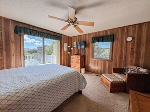 A bedroom with a bed, a desk, a chair, a television, and a ceiling fan. - Hameljuice - Classic 3 BR Oceanside Beach Cottage - close to beach (Southern Shores)