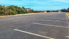 Un grand parking vide, avec des emplacements clairement délimités et un bâtiment en arrière-plan.