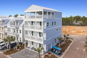 A multi-story building with balconies, a covered parking area, and a construction site in the background.