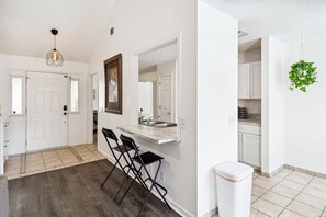 Experience a clean and minimalist space with a kitchen, seating area, and hallway.
