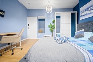 Cozy retreat with a large bed, desk, and wardrobe, perfect for a productive stay.