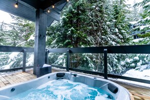 A hot tub on a wooden deck with a view of snow-covered trees. - Ski-In/Ski-Out Access | 5BR Retreat | Hot Tub | Double Garage | Managed by Aloha Whistler (Whistler)