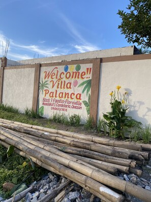 Señal de bienvenida de Villa Palanca con un número de contacto y detalles de ubicación.
