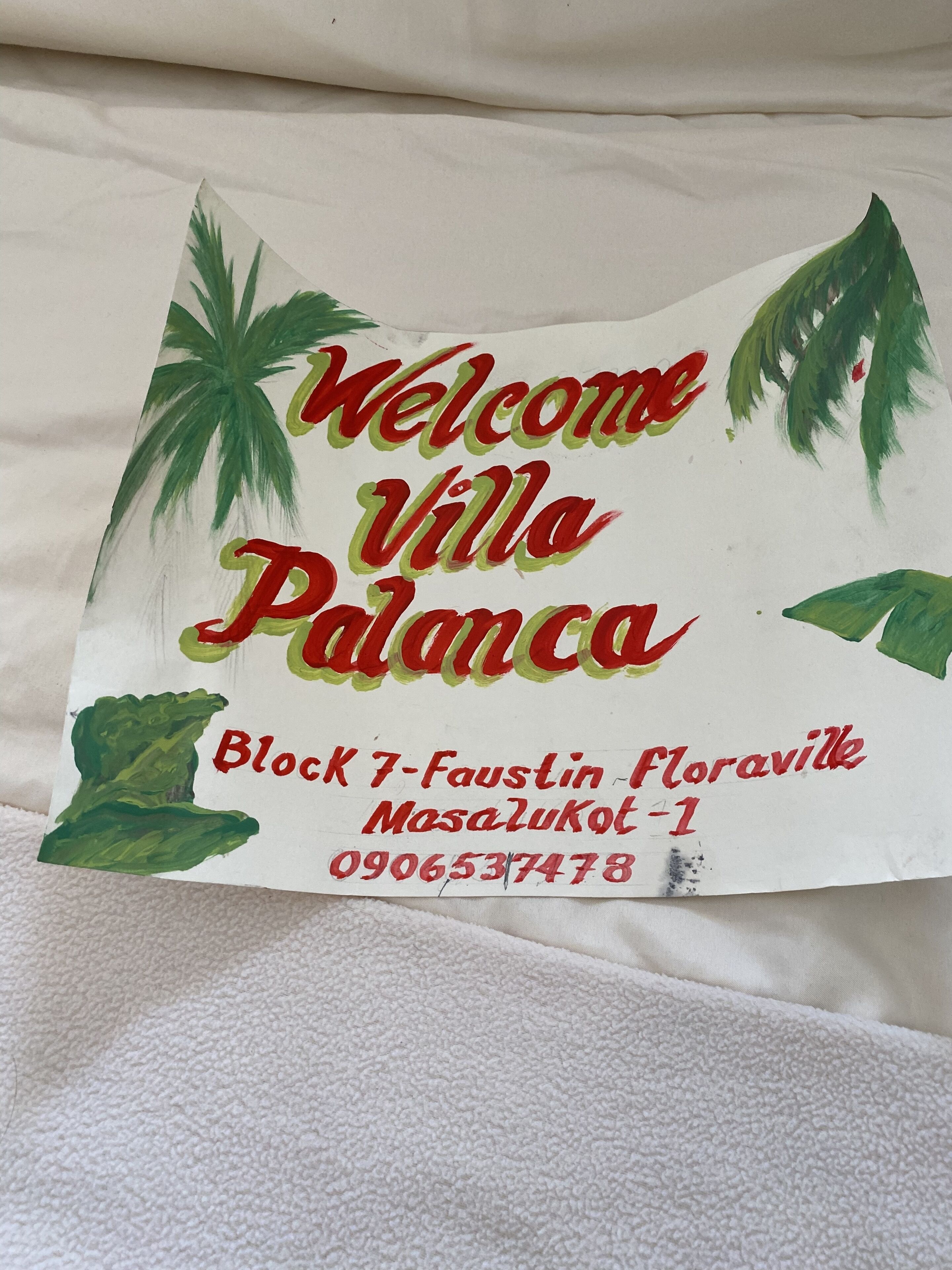 Señal de bienvenida de Villa Palanca con información de contacto.