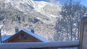 A wooden hot tub with a view of snow-covered mountains. - Magnificent 8-person Meribel Centre apartment with Nordic bath on terrace (Les Allues)