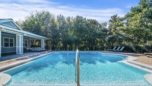 A swimming pool with a clear blue water, surrounded by lounge chairs and a building with a covered patio. - 30A Perfect for 2-Private Beach-Tennis/ Pickle ball/Tesla Universal EV Charger (Santa Rosa Beach)