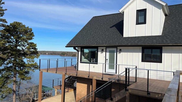 A house with a deck, a staircase, and a view of a lake. - Modern Lakefront Views at Lake Hickory Haven (Hickory)
