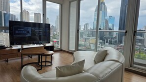 Una sala de estar moderna con un televisor grande, un sofá y un comedor.