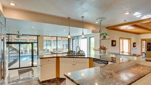 A spacious kitchen with a large island, modern pendant lights, and a view to the outside. - Stien Oasis: Heated Indoor Pool Oasis With Theater, Bar&Tennis Court. (Canfield)
