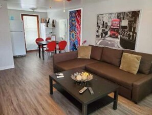 Relax in this stylish living room with a sofa, coffee table, and dining area.